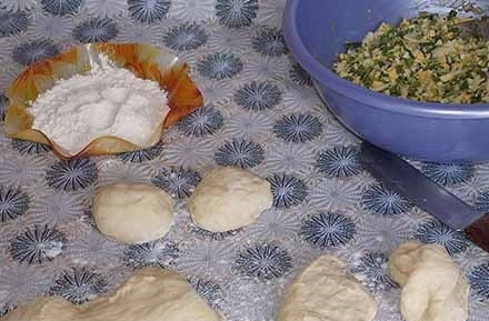 1. Этап. Пирожки с луком и яйцом на дрожжевом тесте: 8. После второго подхода можно начинать лепить пирожки. Отщипните кусочек теста, разровняйте и выложите в центр начинку.