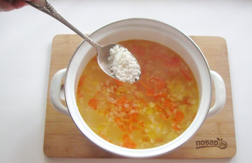 1. Этап. Рассольник без картошки: В кастрюлю с куриным бульоном выложите лук с морковью. Проварите суп 5 минут. После добавьте промытый рис.