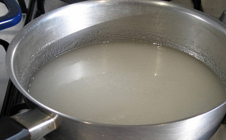 1. Этап. Земляничное пюре: На плиту, включенную на сильный огонь, ставим сотейник, наливаем в него 2 стакана чистой дистиллированной воды и всыпаем 1 килограмм сахара. Когда вода с сахаром закипят, включаем медленный огонь и варим сироп до полного растворения сахара в течение 15-20 минут, интенсивно перемешивая его деревянной лопаткой, для того чтобы он не подгорел и земляничное пюре не пропахло запахом подгоревшего сахара. Готовый сироп снимаем с плиты с помощью полотенца и даем остыть до 35 градусов можно и меньше, например, до комнатной температуры.