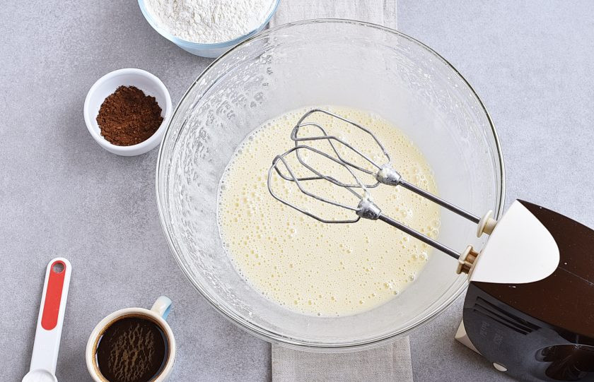 1. Этап. Кофейный пирог: Продолжая взбивать, тонкой струйкой влейте оливковое масло. Взбивайте до легкого загустения смеси.