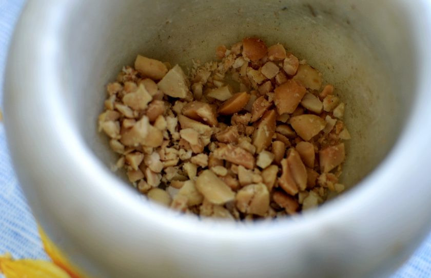 1. Этап. Освежающий салат из огурцов с арахисом: Соленый арахис крупно потолките в ступке или нарежьте ножом. Всыпьте в миску с овощами.