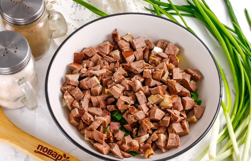 1. Этап. Салат из свиного сердца: Такими же кубиками, как и яйца, нарежьте остывшее свиное сердце, срезая протоки, аорты. Добавьте в емкость.