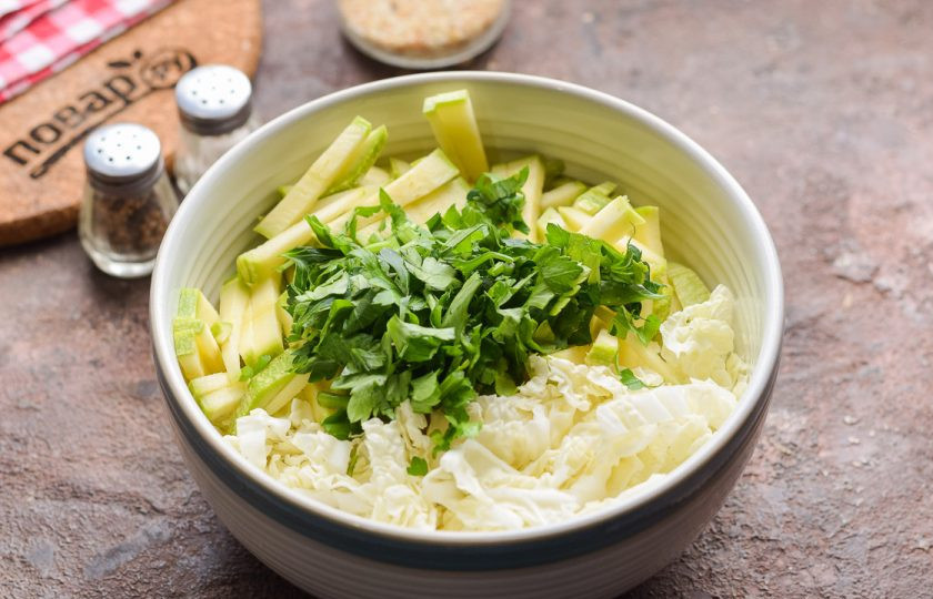 1. Этап. Салат из пекинской капусты и кабачков: Добавьте в салат нарезанную зелень, соль и перец по вкусу.