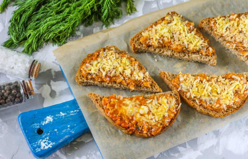 1. Этап. Бутерброды с килькой в томатном соусе: Застелите противень пергаментной бумагой или просто выложите на него подготовленные бутерброды. Разогрейте духовку до 200 градусов и поместите в нее противень. Запекайте около 5-6 минут до расплавления сыра.