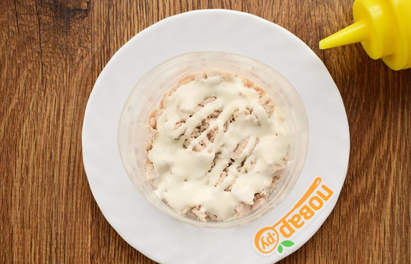 1. Этап. Салат Женская фантазия с курицей: На блюдо поставьте сервировочное кольцо. Выкладывайте салат слоями, каждый немного приминайте: половину куриного мяса, майонез сеточкой;