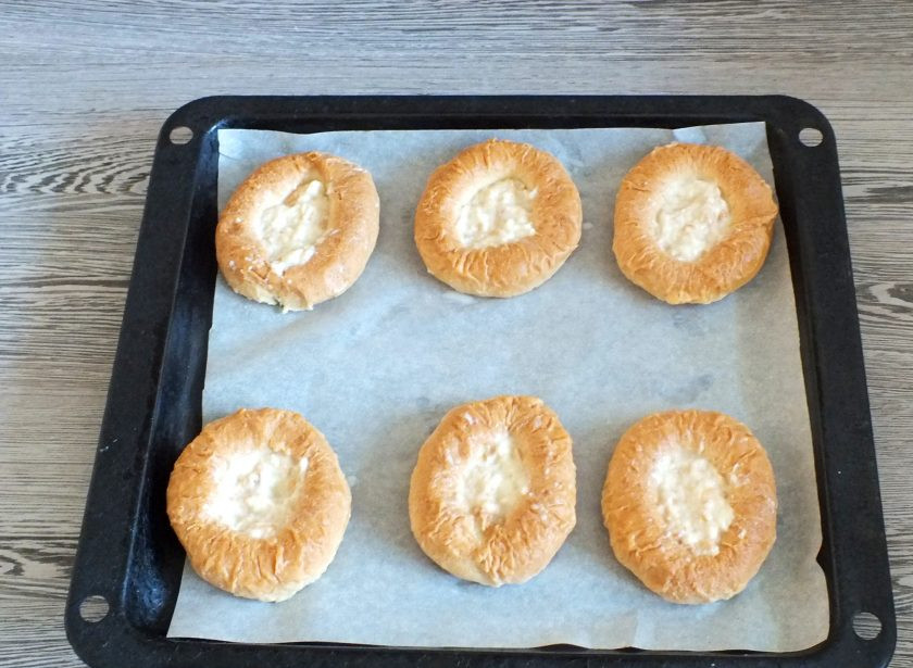 1. Этап. Мини-пиццы из баранок: Подготовленные основы выложите на противень застеленный пергаментом. Перед тем как выложить донышко, массу хорошо отожмите. Распределите в отверстие баранки основы донышко. Включите духовку на 200 градусов.