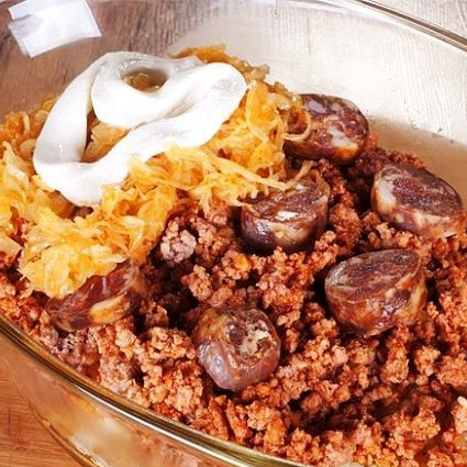 1. Этап. Слоеная капуста по-трансильвански: Берем форму для выпекания. На дно выкладываем третью часть капусты, затем половину риса и половину мяса с колбасками (слоями).