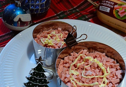 1. Этап. Салат слоёный Снеговик: Колбасу нарезать мелко и разложить на перец + майонез, слегка утрамбовать.