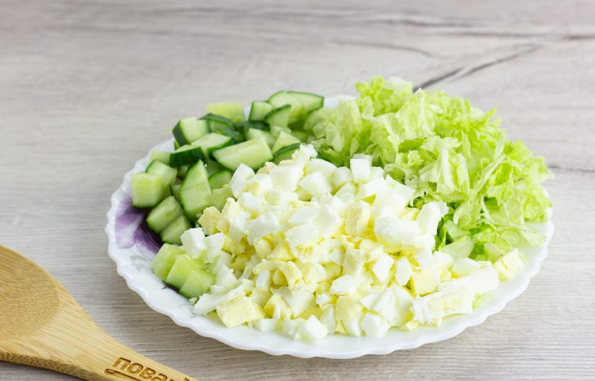 1. Этап. Салат Маркиза: Овощи помойте и обсушите, яйца очистите. Нарежьте кубиком яйца и огурец. Капусту нарежьте произвольно, но не очень крупно.