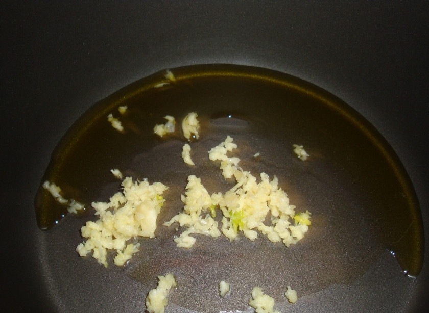 1. Этап. Куриный плов в мультиварке: 2. Включаем мультиварку и выставляем режим «Выпечка», время - 40 минут. Затем наливаем в мультиварку немного растительного масла и выкладываем чеснок. Закрываем крышкой и обжариваем примерно 10 минут.