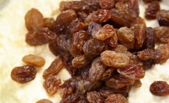 1. Этап. Румынский козунак с творогом: Пока тесто подходит, приготовьте начинку. Для этого смешайте творог с яйцом, сахаром, куркумой, цедрой и сметаной. Добавьте изюм и тщательно все перемешайте.