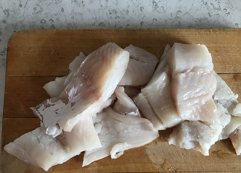 1. Этап. Рыбный салат Раковые шейки: Промываем филе трески, но можно использовать любую другую белую рыбу: минтай или хек. Нарезаем филе на куски и, когда вода закипит, кладем в кастрюлю. Варим до готовности около 15 минут. По желанию, воду можно посолить и добавить лимонный сок.