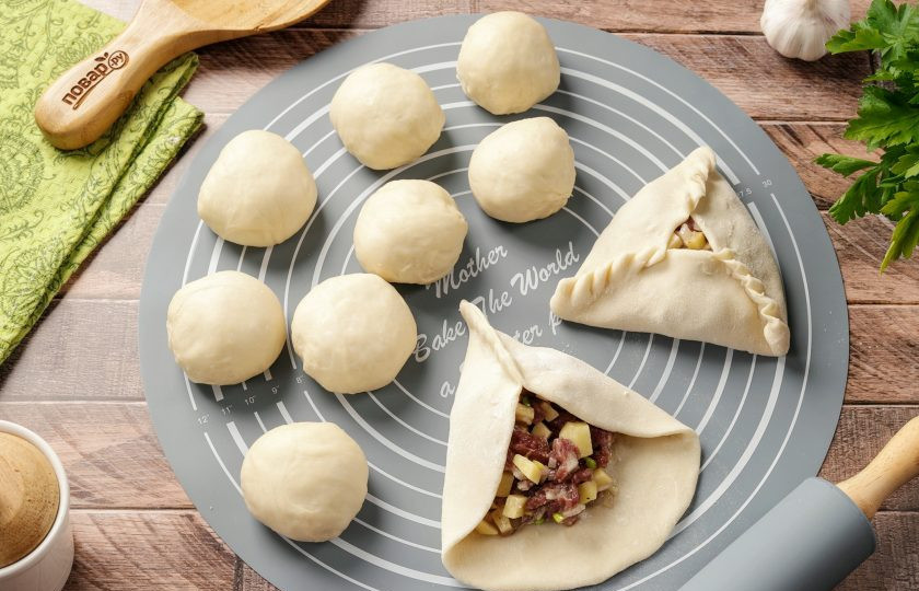 1. Этап. Эчпочмак без дрожжей: Каждый кусочек раскатайте в круг, размером с чайное блюдце (рабочую поверхность в процессе посыпайте слегка мукой) и выложите начинку. На один эчпочмак идёт по весу примерно столько же начинки, сколько весит кусочек теста. Сформируйте треугольник.