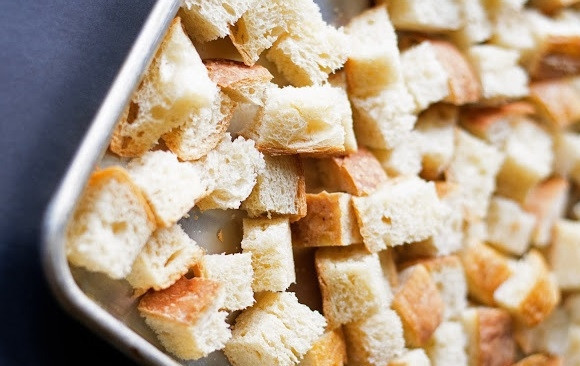 1. Этап. Салат из овощей с сухариками: 1. Несколько ломтиков хлеба нарежьте кубиками и выложите на противень. По желанию можно посолить, добавить специи, сбрызнуть растительным маслом. Но можно обойтись и без всего этого. Отправьте противень в разогретую до 200 градусов духовку и запекайте до румяности, периодически помешивая.