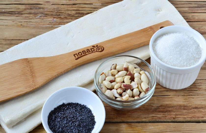 1. Этап. Ушки-завитушки: Подготовьте все необходимые ингредиенты. Слоеное тесто выньте из морозилки, чтобы оно разморозилось. Арахис поджарьте в духовке или в микроволновке, включите функции 