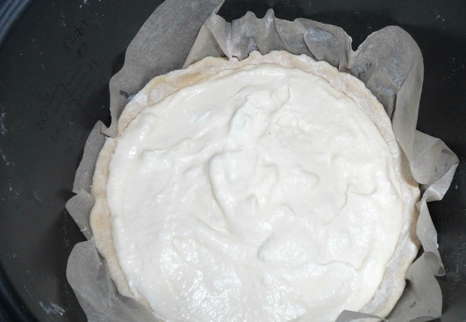 1. Этап. Творожная Лакомка на песочном тесте: Поместите бумагу с тестом в чашу мультиварки. Сверху влейте творожную начинку. Включите режим 