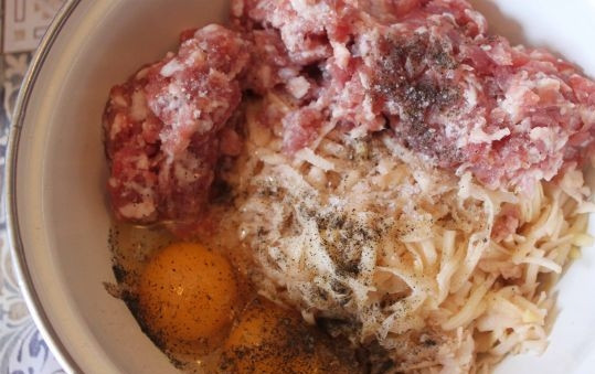 1. Этап. Драники со свининой: 2. Мясо моем, нарезаем кусочками и пропускаем через мясорубку, отправляем его к картошке и луку, вбиваем яйца, солим и перчим, все тщательно перемешиваем.