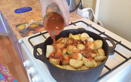 1. Этап. Свиные ребрышки с картошкой в казане: 6. Подсолите немного по вкусу. Сверху выложите картофель, его тоже немного присолив. Томатную пасту разведите водой. Добавьте щепотку перца, соли и измельченную зелень. Вылейте соус в казан.