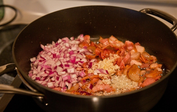 1. Этап. Суп с солеными огурцами: Добавить лук и морковь, обжаривать, постоянно помешивая, до тех пор, пока овощи не станут золотистыми. Выложить помидоры или томатную пасту, посолить, поперчить, перемешать и оставить под крышкой при выключенном огне.