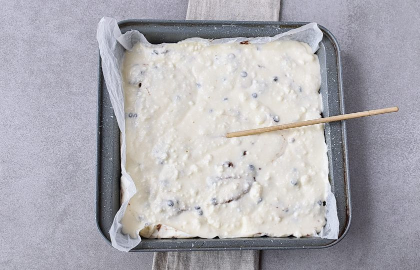 1. Этап. Шоколадный пирог с творогом: Вылейте сверху творожную массу. С помощью шпажки слегка перемешайте в виде узоров, захватывая слой темного теста.