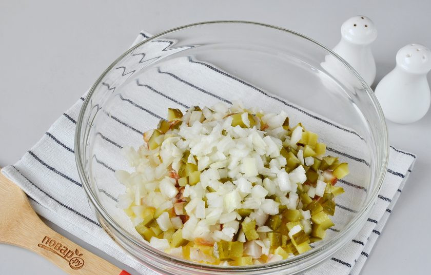 1. Этап. Салат с копченой рыбой: Порежьте репчатый лук, ошпарьте кипятком и добавьте в салатник.