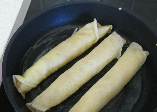 1. Этап. Блины с сосиской: 5. На сковороду отправить немного сливочного масла и растопить. Выложить блины и обжарить на среднем огне до аппетитной корочки. Подавать такую закуску можно как горячей, так и холодной.