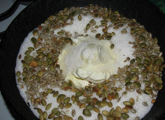 1. Этап. Вареный сахар: В кастрюлю выложите сметану и засыпьте сахар. Поставьте на медленный огонь и начинайте нагревать, периодически помешивая. Через несколько минут всыпьте туда семечки.