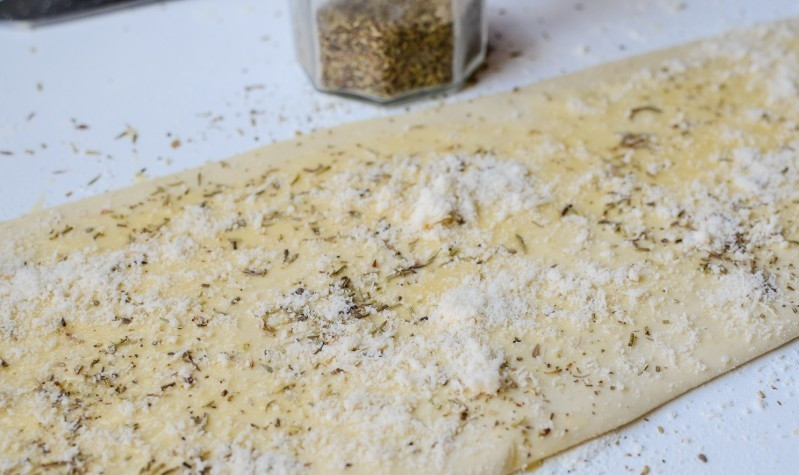 1. Этап. Слоеные палочки с сыром: Тесто посыпать специями и сыром.
