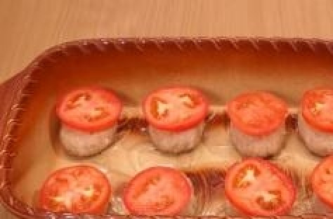 1. Этап. Котлеты с сыром и помидорами: 8. Смазываем форму для запекания или противень растительным маслом, раскладываем котлеты. На каждую котлетку кладем по одному кружочку помидора.