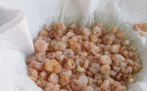 1. Этап. Салат из пекинской капусты с креветками: 1. Достаньте из морозилки креветки, бросьте их в кипящую воду, предварительно подсолив ее. Подождите, пока вода закипит, и еще подержите морепродукты полторы минуты. Возьмите дуршлаг, слейте воду с креветок через него, так морепродукт останется чистым. Остудите креветки при комнатной температуре, высыпьте их на приготовленную бумажную поверхность и подождите, пока они обсохнут.