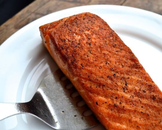 1. Этап. Нисуаз с лососем: Пока овощи и яйца остывают, лосось посолите и поперчите. Разогрейте на сковороде растительное масло, обжарьте лосось с двух сторон до золотистого цвета. Можете прикрыть сковородку крышкой и дать рыбе пропариться.