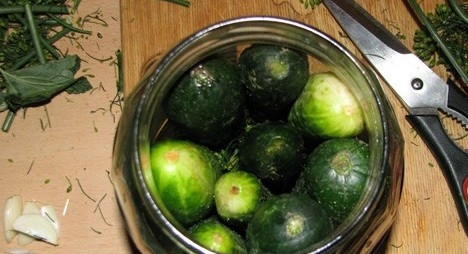 1. Этап. Маринованные огурцы сладкие: Уложить огурчики и зелень в банки.