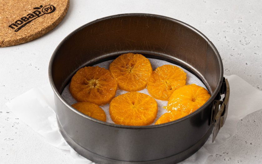 1. Этап. Постный пирог с мандаринами: Выложите в застеленную форму кружочки мандаринов.