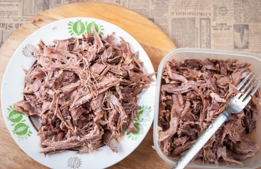 1. Этап. Хрустальный холодец из домашнего петуха: 7. На дно форм, в которые будете заливать холодец, выложите немного чеснока, измельченный перец и специи (если вы их не добавляли в бульон). Разделанное мясо следует хорошо перемешать и в таком виде частями выкладывать его в наши тарелки.