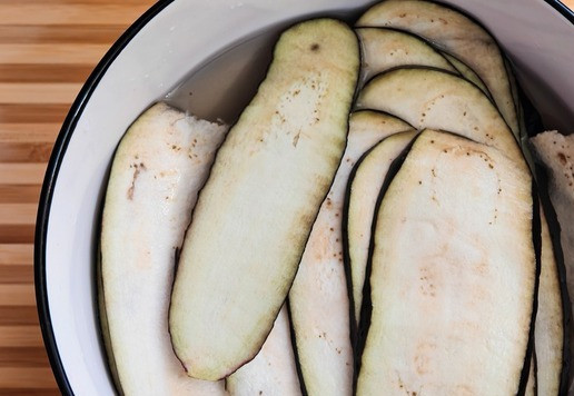 1. Этап. Салат с баклажанами и индейкой: Переложить нарезанные слайсы в подсоленую холодную воду на 15-20 мин. чтобы ушла лишняя горечь.