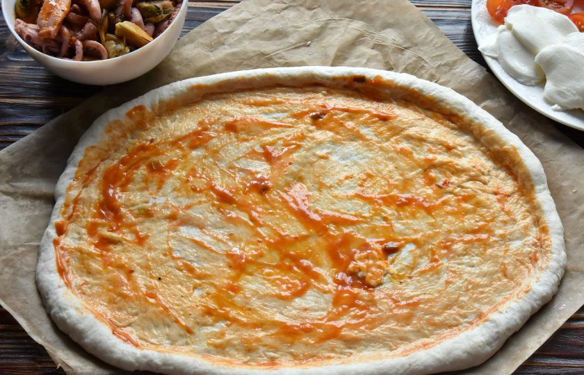 1. Этап. Пицца Том Ям: Разделите тесто на три части, весом по 310 граммов каждая. Каждую часть распределите на силиконизированной пергаментной бумаге и растяните ее руками, смазанными растительным маслом, в лепешку. Смажьте поверхность теста пастой 