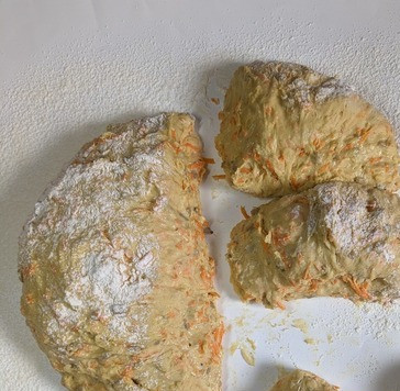 1. Этап. Морковные булочки Гулеродсбруд: Теперь надо разделить тесто на 12 частей, оно липкое, работать с ним не очень легко, поэтому присыпая мукой и с помощью силиконовой лопатки, отделить кусочки теста. И прокручивая лопаткой, сформировать булочки.