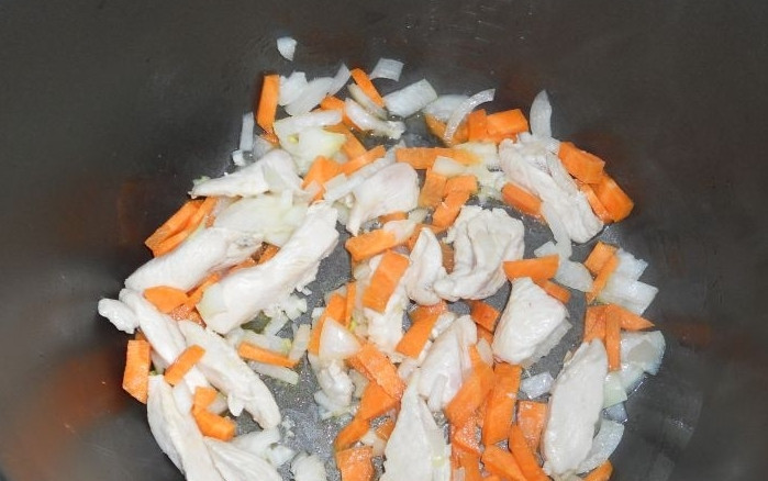 1. Этап. Суп с курицей в мультиварке: Репчатый лук нарезаем небольшими кубиками, а морковь соломкой, выкладываем овощи к курице и жарим все вместе еще 10 минут на том же режиме.