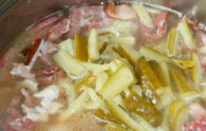 1. Этап. Солянка с томатной пастой: В солянку всыпьте нарезанные огурцы и маслины, влейте рассол из-под огурцов.