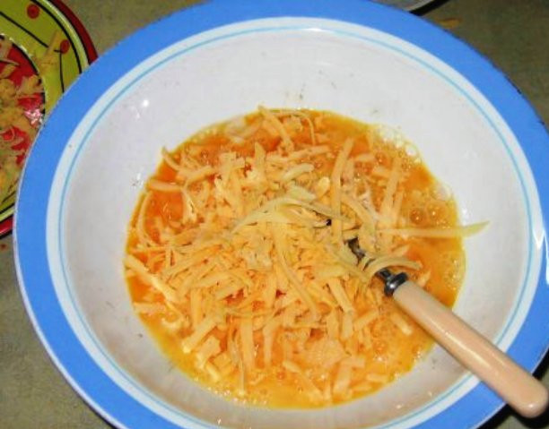 1. Этап. Тыквенная запеканка с сыром: Сыр потрите на терке и половину смешайте с яйцами.