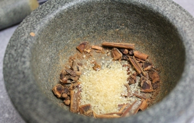 1. Этап. Тесто для коврижки: В ступке измельчите специи: гвоздику и кардамон. Туда же поместите корицу, если она в палочках. В эту смесь приправ добавьте имбирь-порошок или свежий мелко натёртый имбирь. Чтобы перетирать специи было удобнее, можно насыпать в ступку немного сахарного песка. Сюда же добавьте какао.