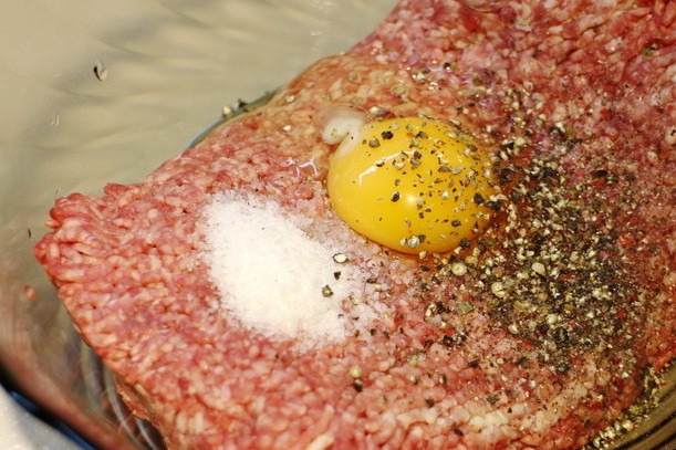 1. Этап. Бризоль в духовке: Для начала необходимо заправить фарш, для этого мы разбиваем в него одно яйцо, солим его и приправляем специями, я обычно обхожусь только молотым черным перцем или смесью перцев. Тщательно все перемешиваем и пока отставляем фарш в сторонку.