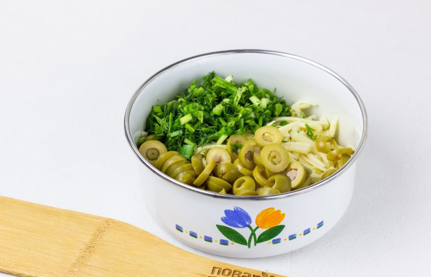 1. Этап. Тортилья с сыром: Добавьте к сыру нарезанные кружочками оливки и рубленную зелень. Перемешайте и попробуйте. Если выбранный сыр не очень соленый, то начинку можно немного посолить.