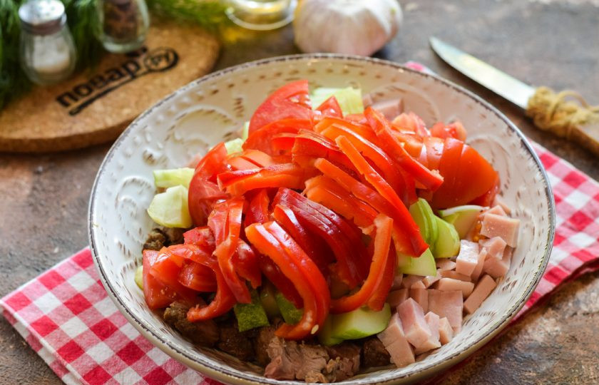 1. Этап. Салат с говядиной и ветчиной: Сладкий перец очистите и ополосните, нарежьте полосками и переложите в салат.