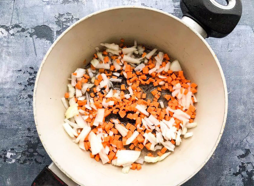 1. Этап. Овощное рагу с капустой и фасолью: Лук с морковью мелко нарежьте, выложите на хорошо разогретую сковороду с растительным маслом и обжарьте в течение 3-4 минут.