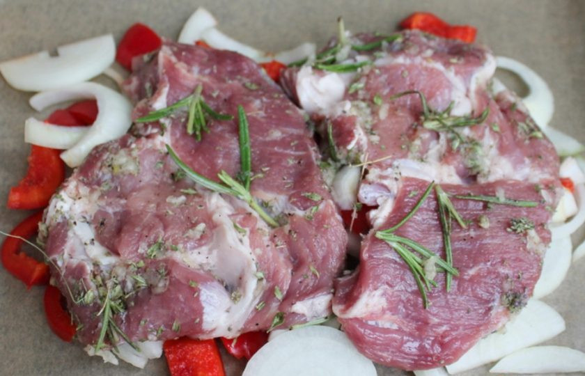 1. Этап. Ошеек в духовке: Лук и болгарский перец нарезаем кусочками и выкладываем на противень. Сверху кладем мясо, отправляем в духовку на 45-60 минут. Готовим при температуре 200 градусов.