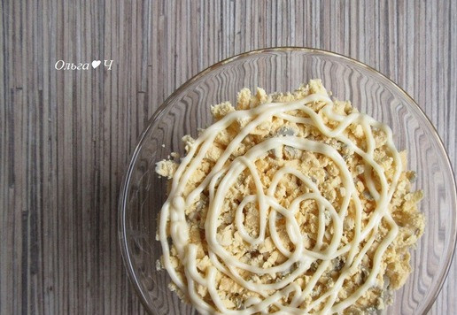 1. Этап. Салат Первый снег с тунцом: Яйца разделите на белки и желтки. Сначала посыпьте салат тертыми желтками, добавьте майонез.