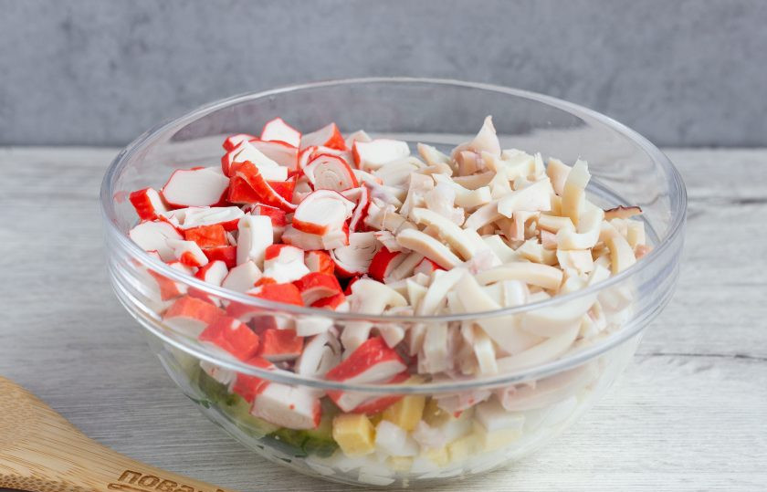 1. Этап. Салат Медуза: Крабовые палочки нарежьте колечками, а кальмаров – тонкими полосками.