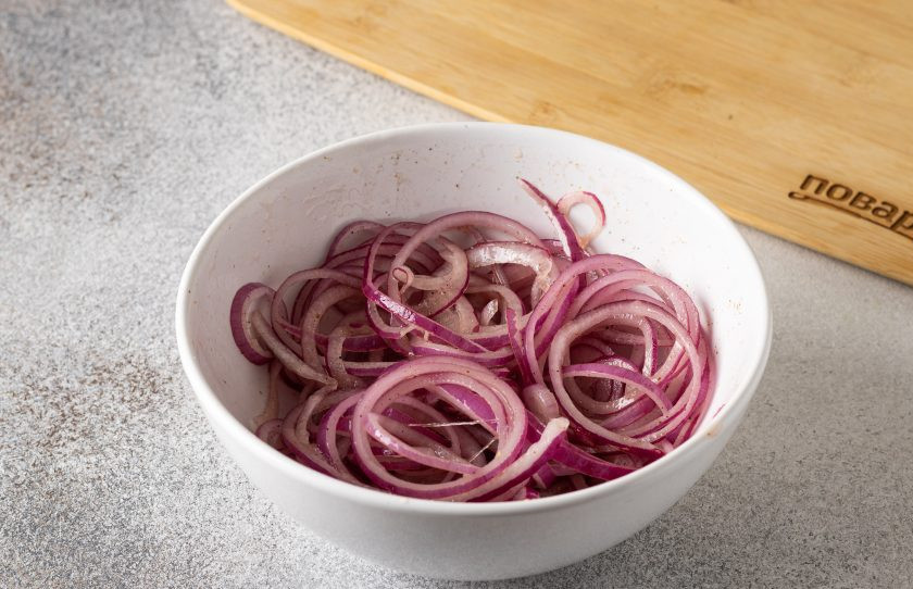 1. Этап. Красный лук в медовом маринаде с пряностями: Лук аккуратно перемешайте. Накройте пленкой и оставьте на полчаса мариноваться при комнатной температуре.