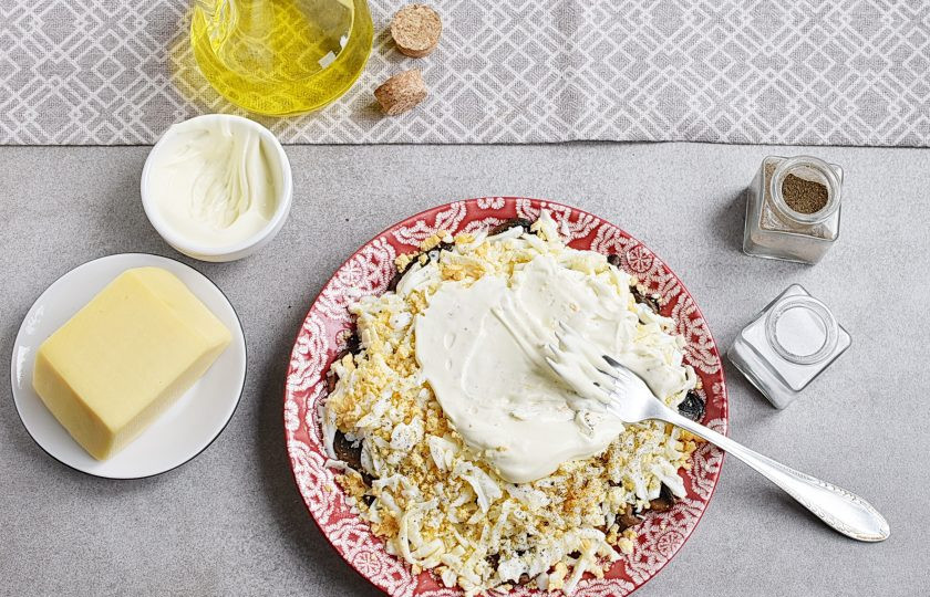 1. Этап. Простой салат с шампиньонами жареными: Смажьте яйца сверху майонезом. Его не должно быть много – это третий секрет. Равномерно тонким слоем вполне достаточно.